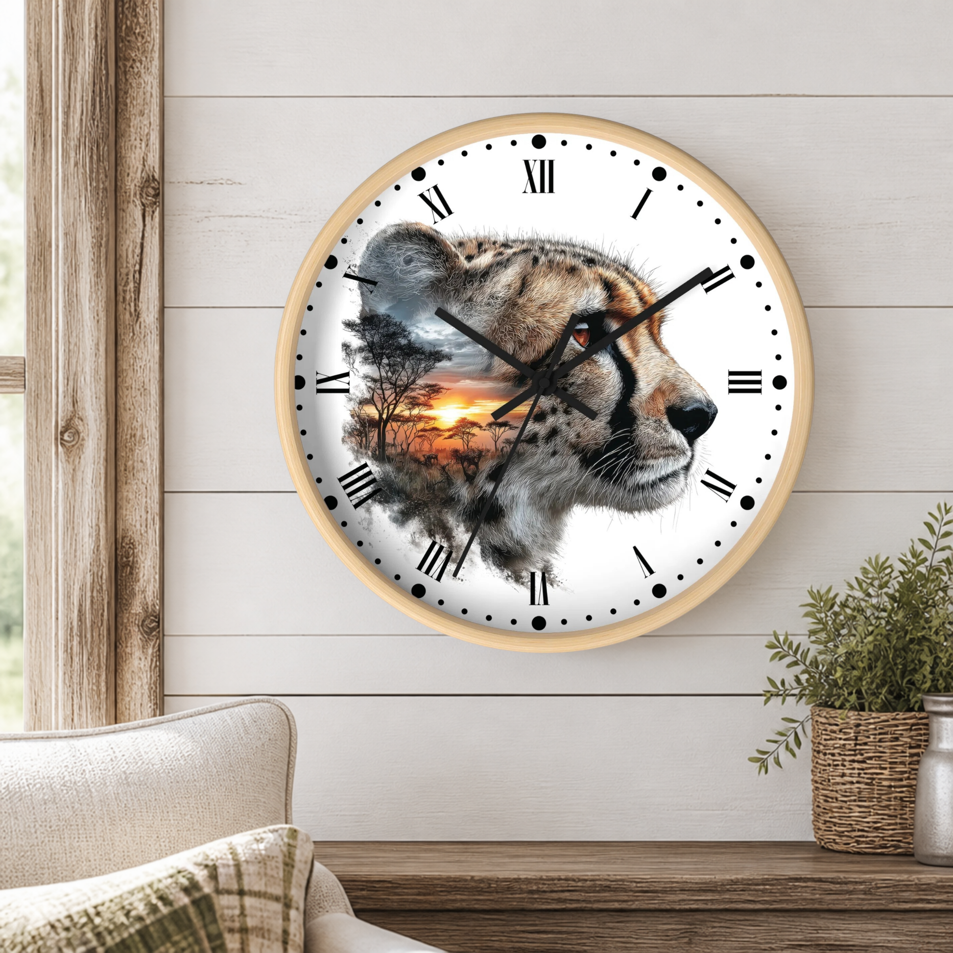 A round wall clock with a light wood frame hangs on a white shiplap wall above a wooden table. The clock face features a photographic cheetah head with a sunset landscape double-exposed print.