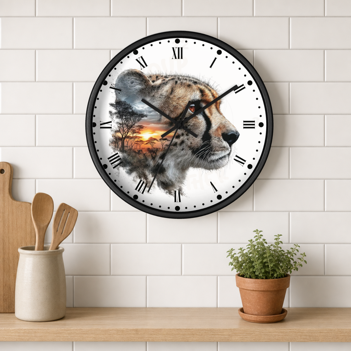A round wall clock with a black frame hangs on a white subway-tile kitchen wall above a wooden shelf. The clock face features a detailed cheetah portrait with a sunset landscape overlay.