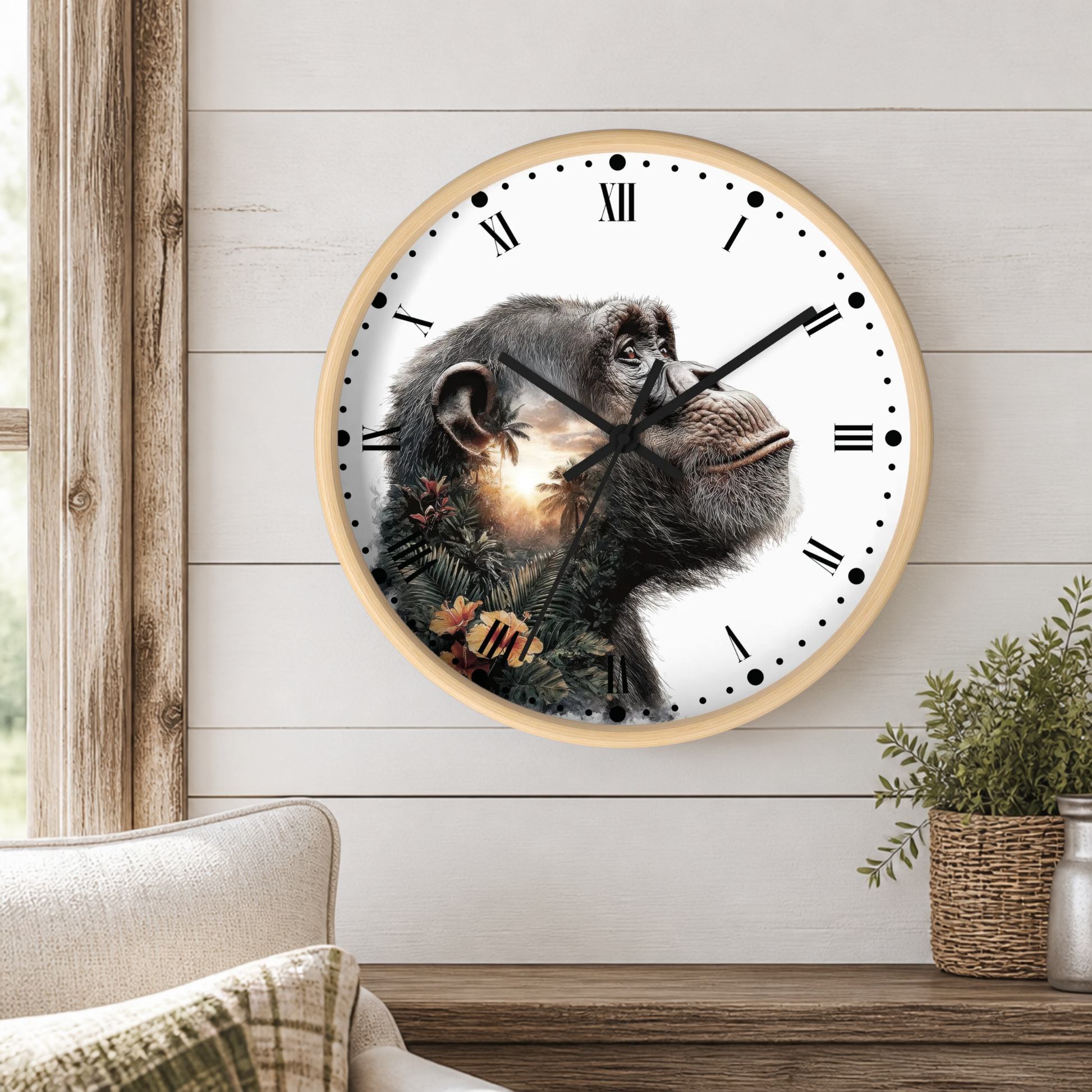 A round wall clock with a light wood frame and a chimpanzee face printed across the clock face, styled on a white wood-paneled wall above a wooden shelf with a plant and a sofa visible.