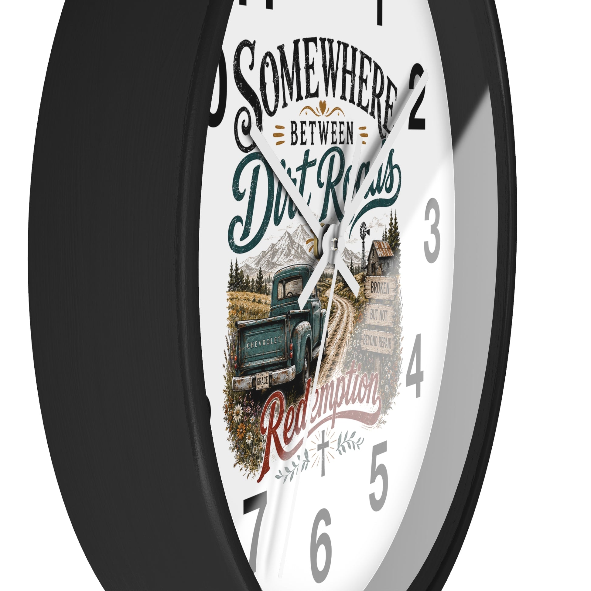 A round wall clock with a black frame and a white face featuring a vintage truck illustration and the text 'Somewhere Between Dirt Roads Red Emporia'.