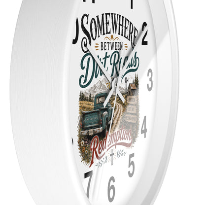 A white round wall clock with a rustic western-themed dial design featuring the text 'Somewhere Between Dirt Roads Red Emporia' and an illustration of a vintage pickup truck on a dirt road.