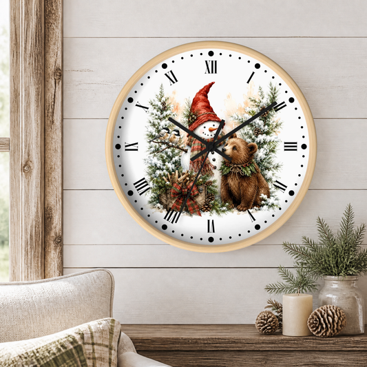 A round wall clock with a light wood frame hangs on a white shiplap wall above a rustic table. The clock face features a winter holiday illustration with a snowman in a red hat, a brown bear, pine trees, and black Roman numerals.