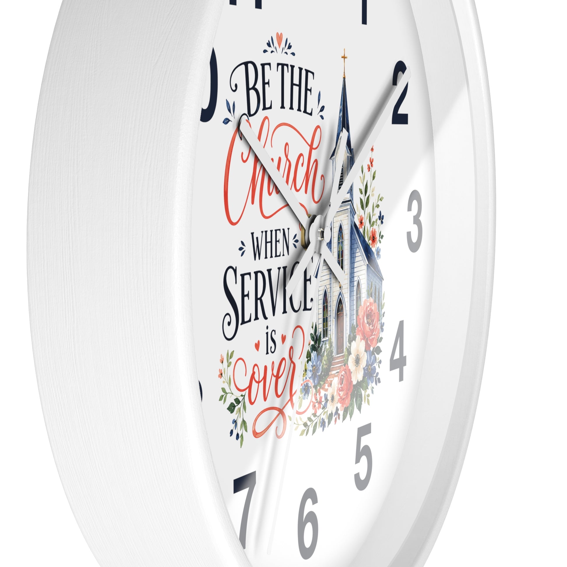 A white round wall clock with a printed church illustration and the phrase “Be the Church When Service is Over” in black and coral script, shown against a white background.