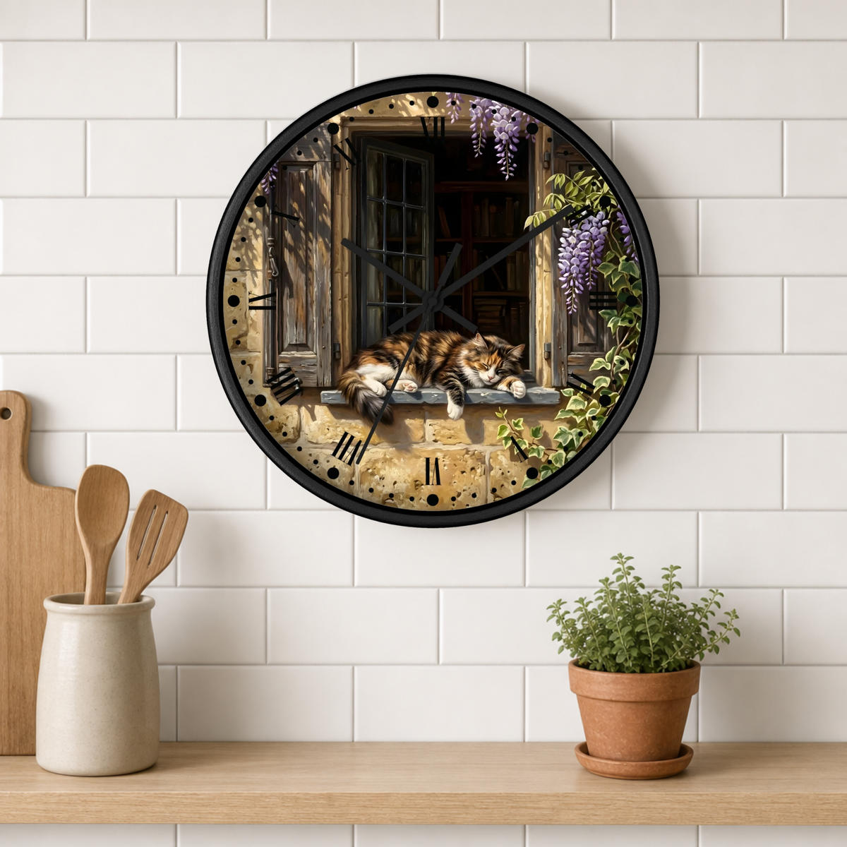 A round wall clock with a black frame hangs on a white subway tile wall above a wooden shelf. The clock face features an artistic print of a cat sleeping on a windowsill with purple wisteria flowers and a rustic stone wall background.