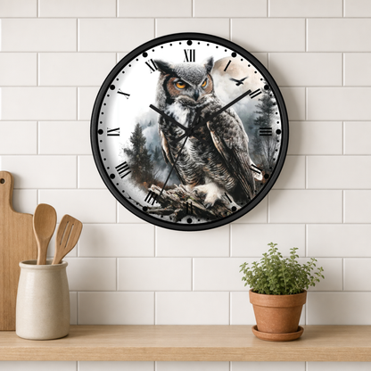 A round wall clock with a black frame and a printed owl illustration on the face, mounted on a white subway-tile wall above a wooden shelf with kitchen utensils and a potted plant.