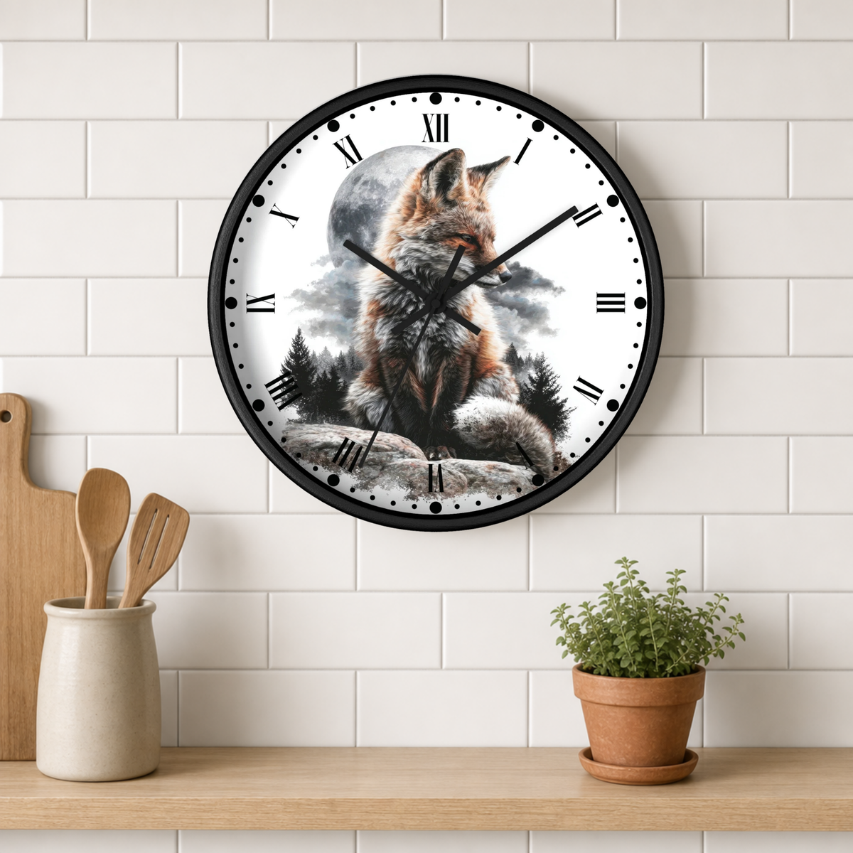 A round wall clock with a black frame hangs on a white subway-tile wall above a wooden shelf. The clock face features a detailed illustration of a fox sitting in front of a full moon and trees.