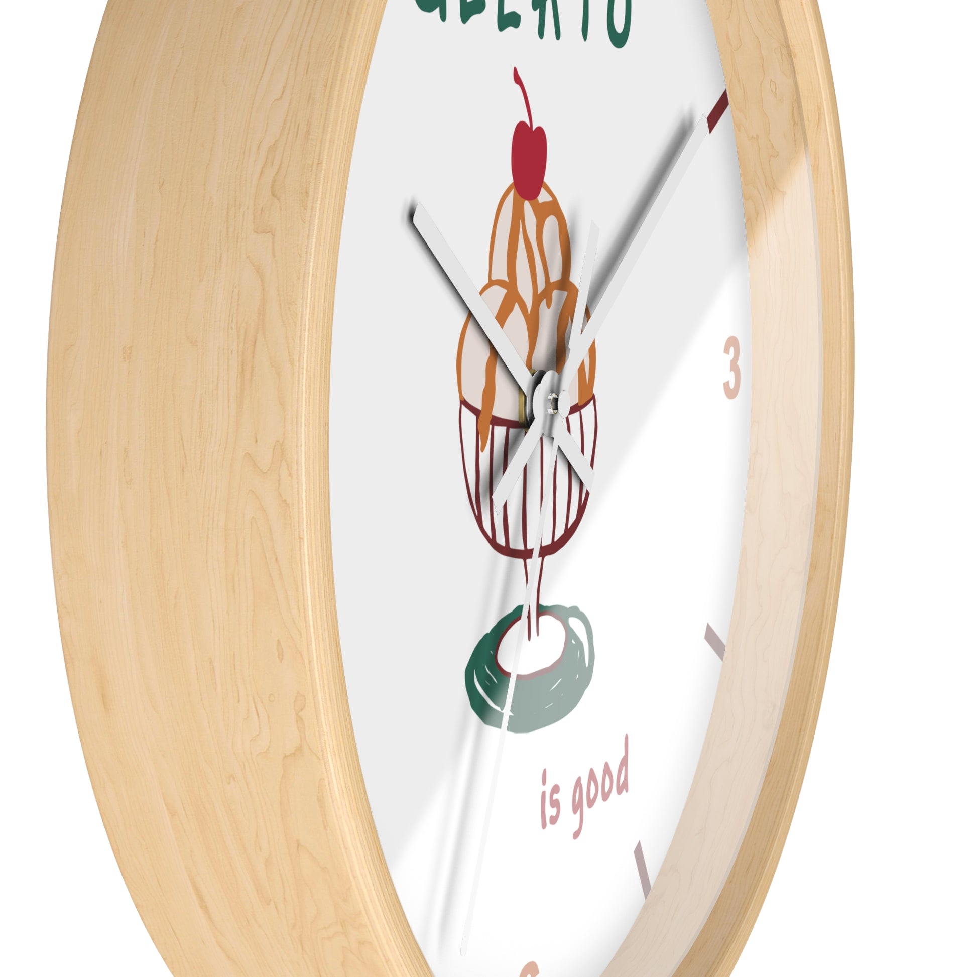 A close-up of a round wall clock with a light natural wood frame and a white face featuring a colorful ice cream cone illustration and the words 'GREAT LATO is good'.