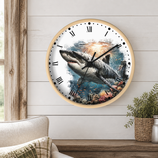 A round wall clock with a light wood frame and a printed shark underwater scene, mounted on a white shiplap wall above a wooden table with a plant and part of a sofa visible.