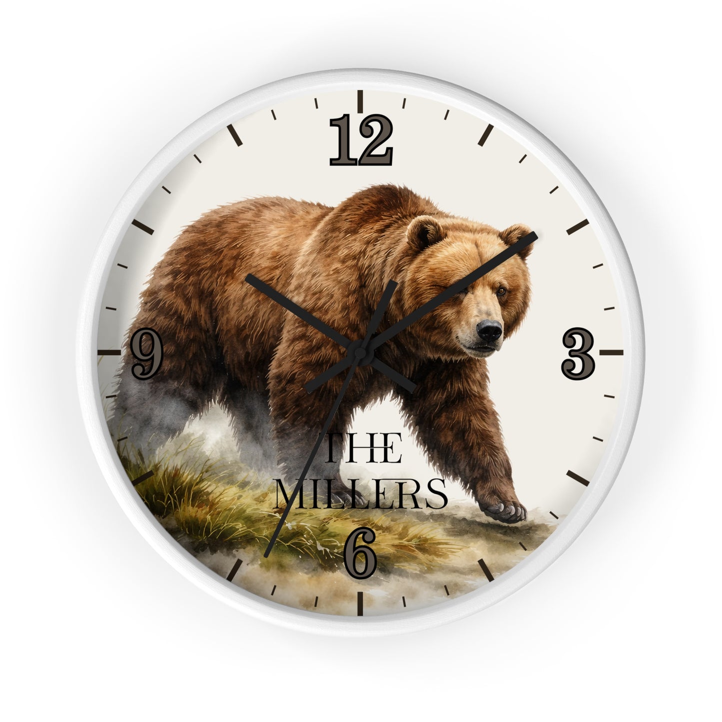 A round wall clock with a white frame and a printed brown bear illustration on the face. The clock has black Arabic numerals, black hour and minute hands, and the words 'THE MILLERS' near the bottom, shown against a plain white background.