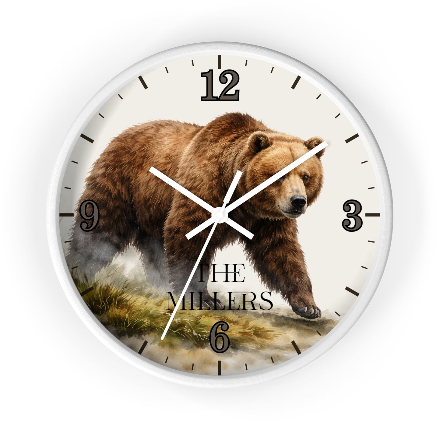 A round wall clock with a white frame and a printed design featuring a brown grizzly bear walking across a grassy landscape. The clock face is off-white with black Arabic numerals and hands, and the words 'THE MILLERS' printed near the bottom.