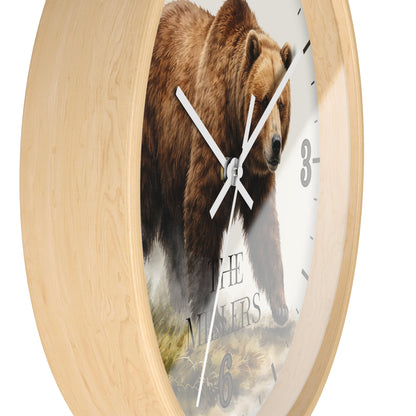 Round wall clock with a light natural wood frame and a printed bear face in the center, with white hands and partial black Arabic numerals visible on a white background.