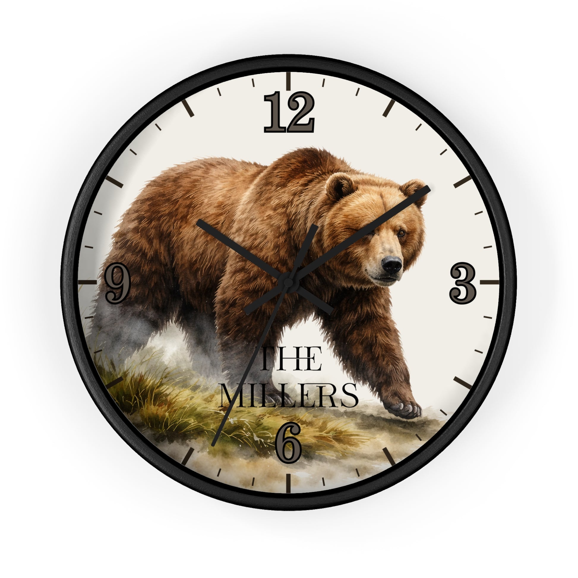A round wall clock with a black frame and a printed bear illustration on the face. The clock includes black Arabic numerals and the text 'THE MILLERS' near the bottom, shown against a plain white background.