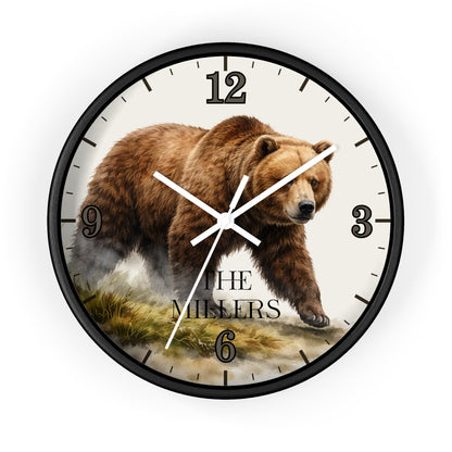 A round wall clock with a black frame and a printed bear illustration on the face. The clock has black Arabic numerals, white hands, and the text 'THE MILLERS' near the bottom.