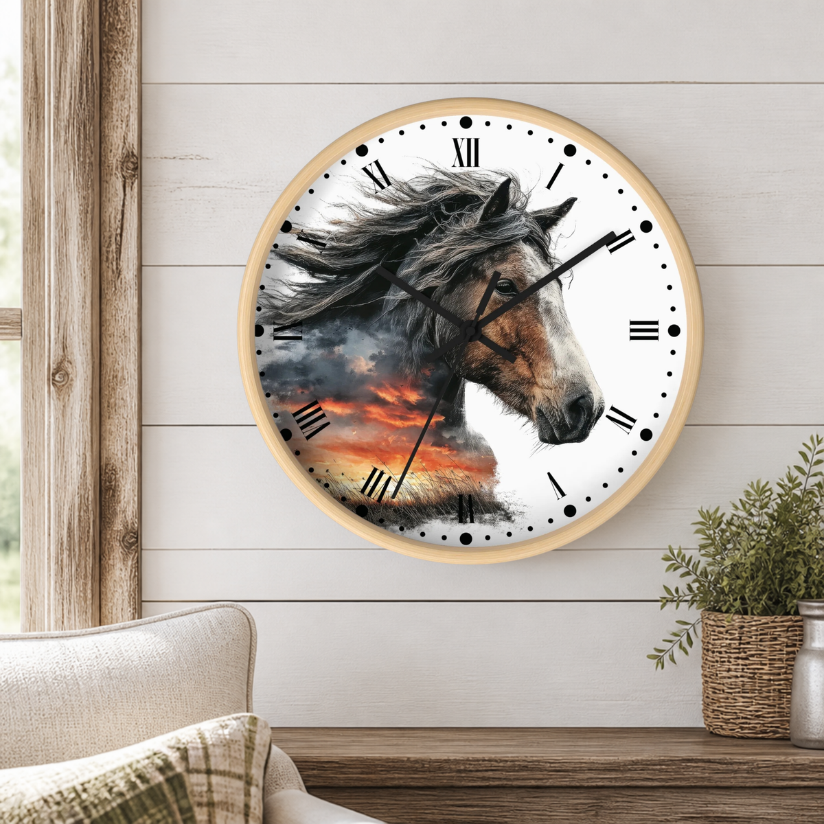 Round wall clock with a light wood frame featuring a horse head illustration over a sunset scene, mounted on a white shiplap wall above a wooden shelf with a plant and part of a sofa visible.