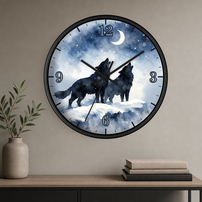 A round wall clock with a black frame hangs on a beige wall above a console table. The clock face features a watercolor-style night scene with two black howling wolves under a crescent moon and stars.