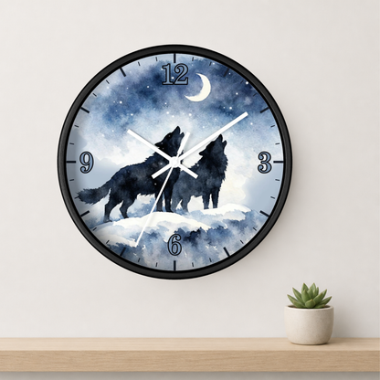 Round wall clock with a black frame and a night sky design featuring two howling wolves, a crescent moon, and blue stars. The clock is mounted on a light wall above a wooden shelf with a small potted succulent.