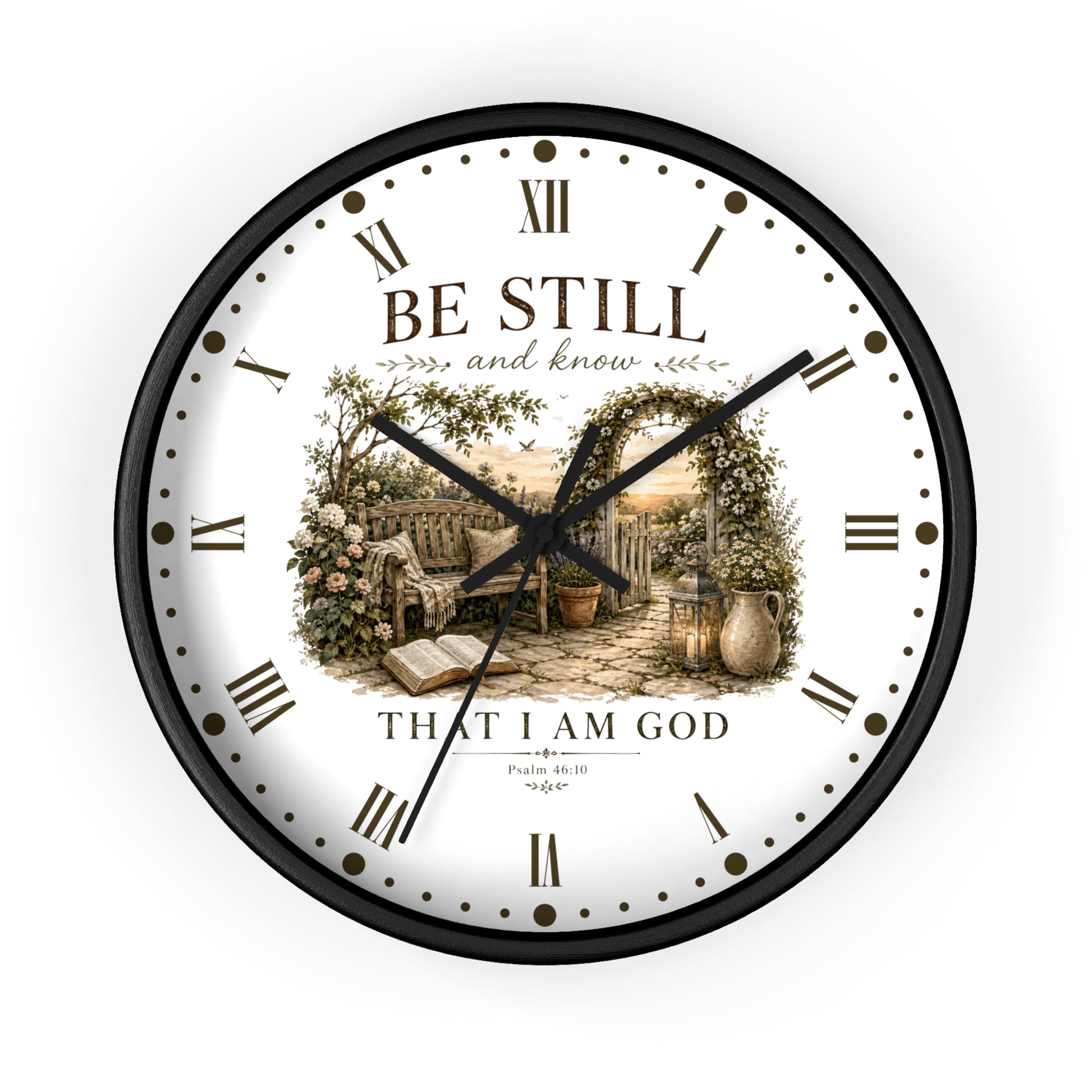 A round wall clock with a black frame and a white face featuring a vintage-style illustration of a garden scene with an open book and the text 'BE STILL and know THAT I AM GOD' with scripture reference Philippians 4:13.