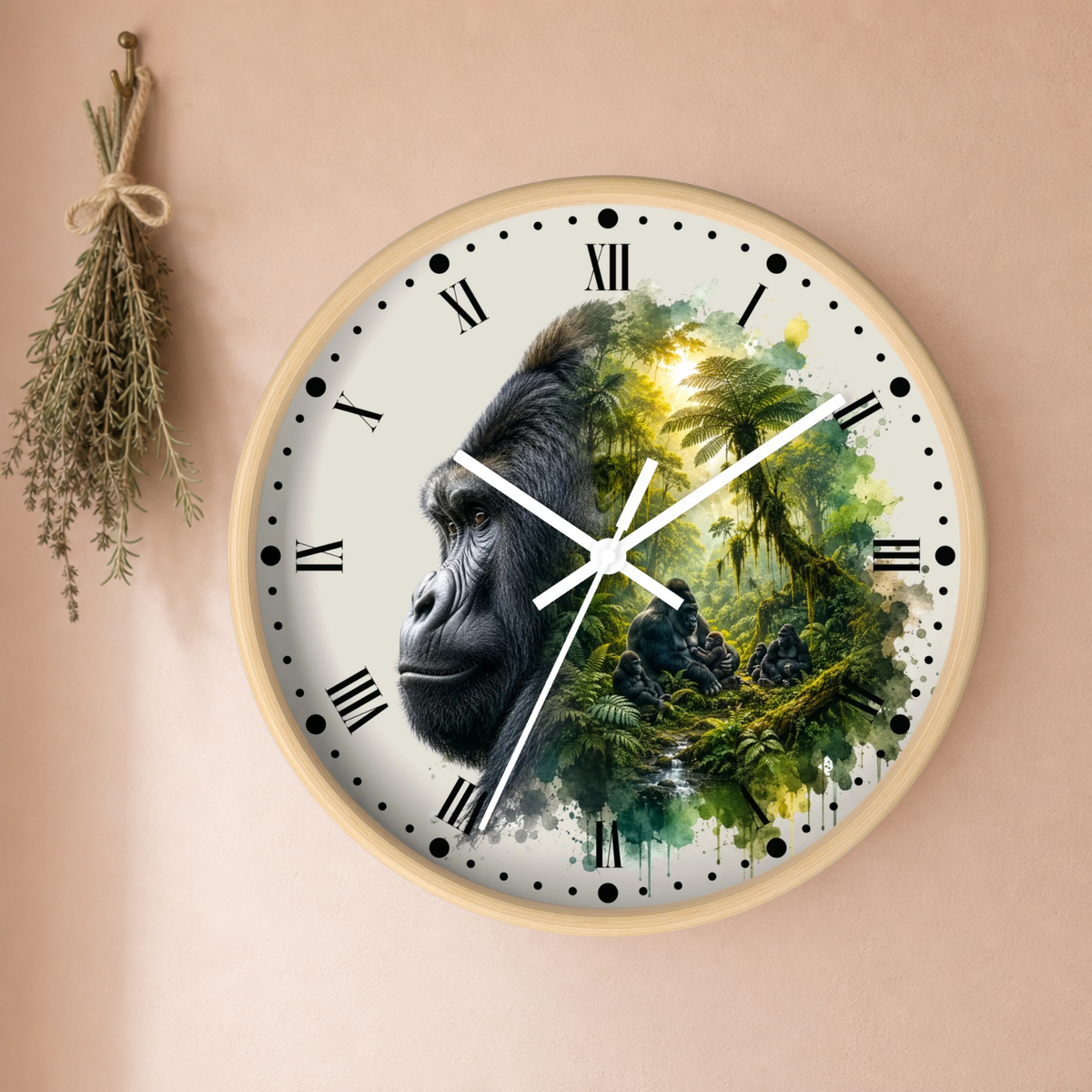 A round wall clock with a light wood frame, featuring a printed design of a gorilla's face merging into a lush green jungle scene. The clock is mounted on a warm beige wall next to a small hanging bundle of dried herbs.
