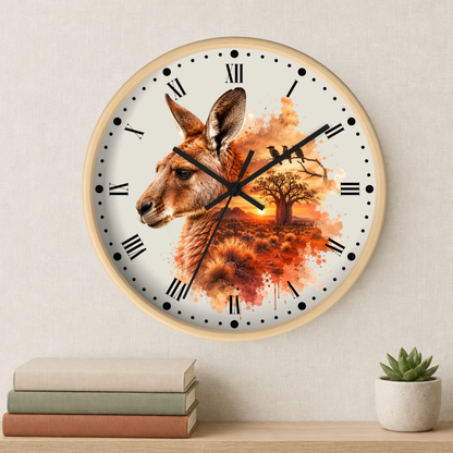 Round wall clock with a light wood frame and a printed kangaroo and autumn landscape design on the face, mounted on a beige wall above a shelf with books and a small succulent.