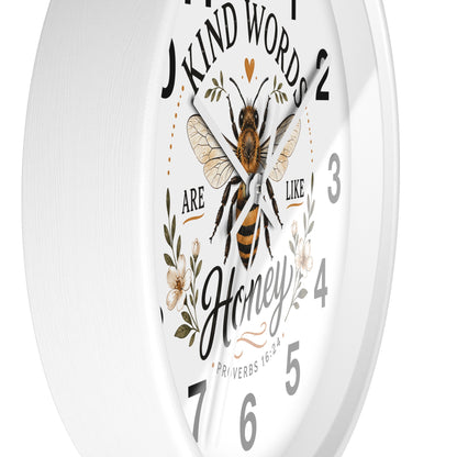 A white round wall clock with a printed bee illustration and the words 'Kind Words Are Like Honey' around the dial, shown against a plain white background.