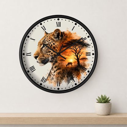 A round wall clock with a black frame and Roman numerals, featuring a leopard and African savanna landscape design on the face, mounted on a light gray wall above a wooden shelf with a small potted succulent.