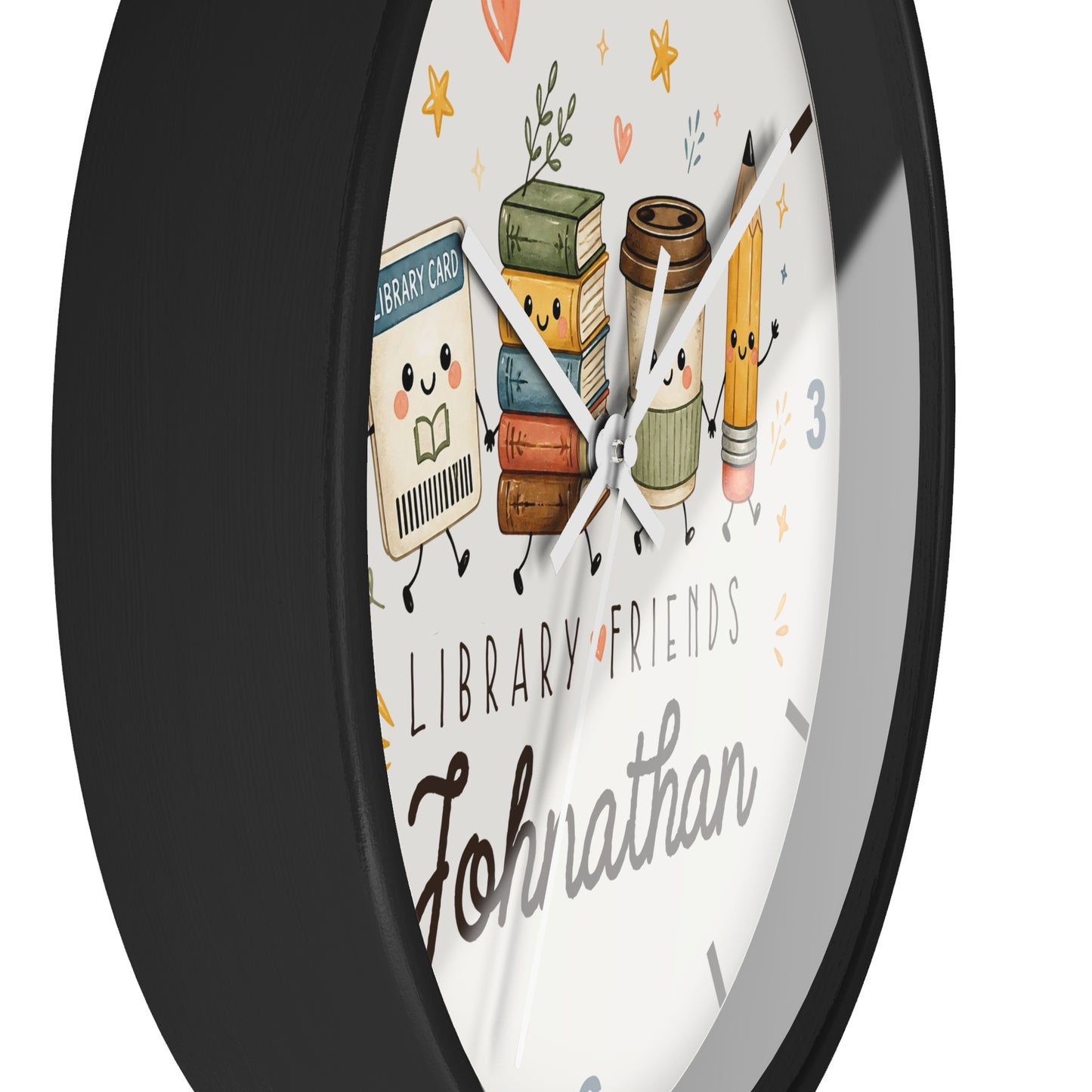 A round wall clock with a black frame and a white face, decorated with cute cartoon library-themed characters including books, a coffee cup, a pencil, and the words 'LIBRARY FRIENDS' and the name 'Johnathan'.