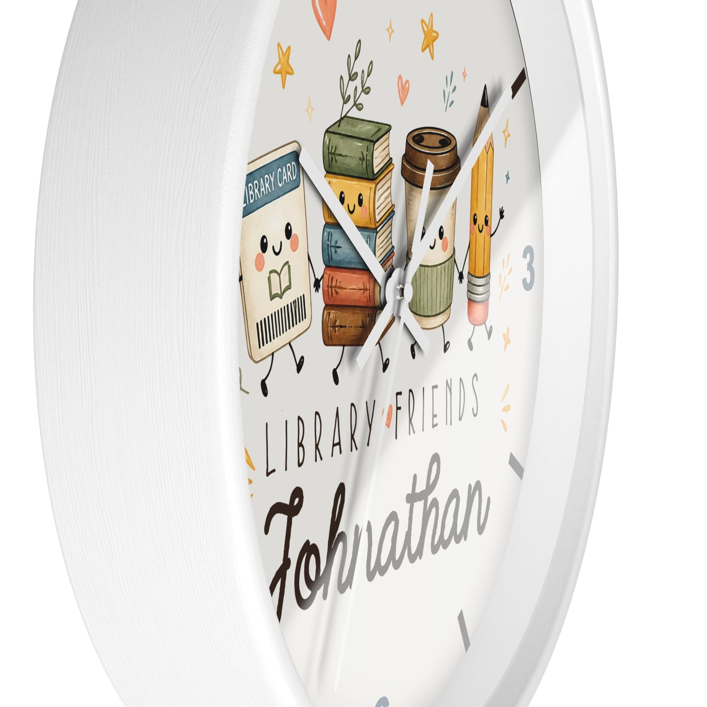 A round white wall clock with a cute library-themed illustration on the face, featuring cartoon books, a coffee cup, a pencil, and the text 'LIBRARY FRIENDS' and the name 'Johnathan'.