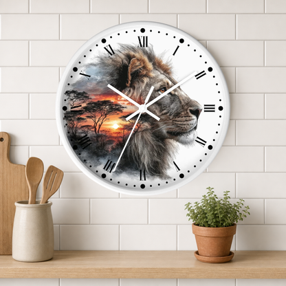 A round wall clock with a printed lion head and African savanna sunset design, mounted on a white subway-tile wall above a wooden shelf with kitchen utensils and a potted plant.