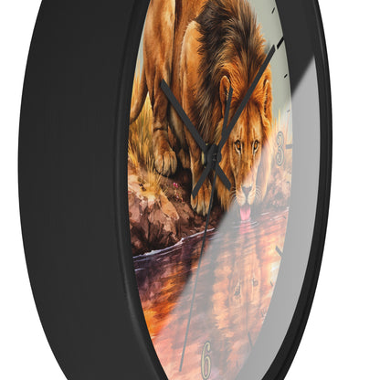 A round wall clock with a black frame and a printed lion drinking from water on the face, shown against a plain white background.