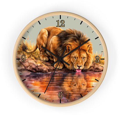 Round wall clock with a light wood frame and a printed lion drinking from water artwork on the face, shown against a plain white background.