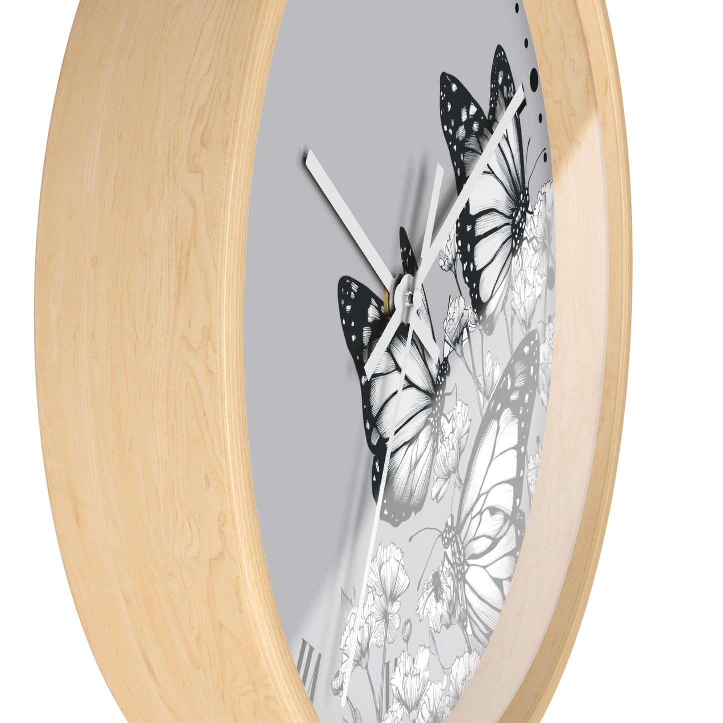 Round wall clock with a light natural wood frame and a gray dial featuring black and white butterfly and floral artwork.