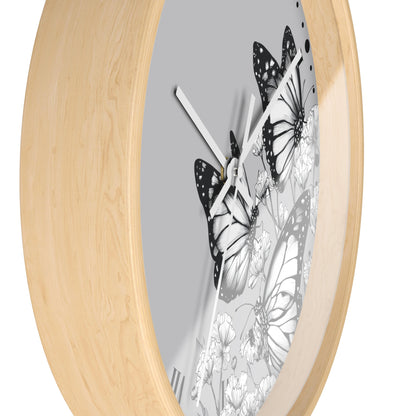 Round wall clock with a light natural wood frame and a gray dial featuring black and white butterfly and floral artwork.