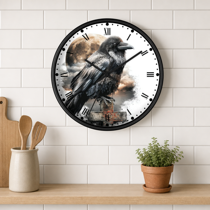A round wall clock with a black frame hangs on a white subway-tile wall above a wooden shelf. The clock face features a detailed illustration of a raven perched against a cloudy moonlit sky.