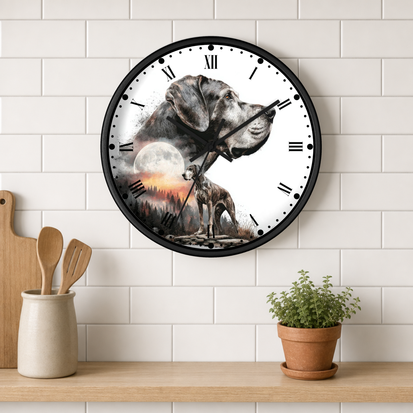 A round wall clock with a black frame and a printed illustration of a gray dog against a white background with a moon and sunset motif. The clock is mounted on a white subway tile wall above a wooden shelf with a small potted plant and wooden utensils.