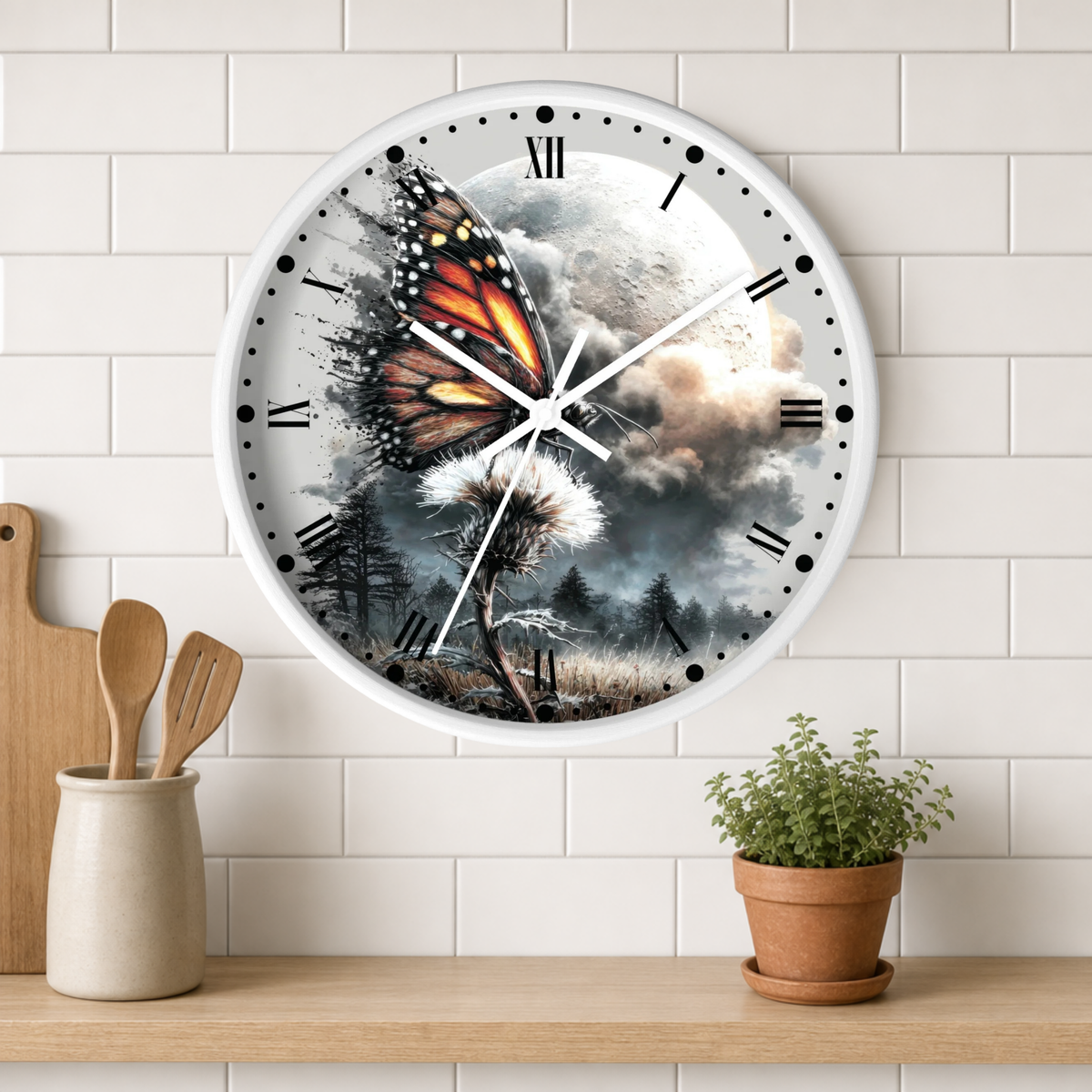 A round wall clock with a white frame and a detailed fantasy-style print of a monarch butterfly over a dandelion in a stormy landscape. The clock is mounted on a white subway tile wall above a wooden shelf with a small potted plant and wooden utensils.