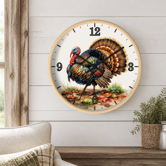 A round wall clock with a light wood frame and a white face, featuring a detailed illustration of a turkey on the front. The clock is mounted on a white shiplap wall above a wooden mantel with a small potted plant.