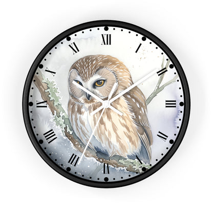 A round wall clock with a black frame and Roman numerals, featuring a detailed illustration of a brown and beige owl perched on a snowy branch on the clock face.