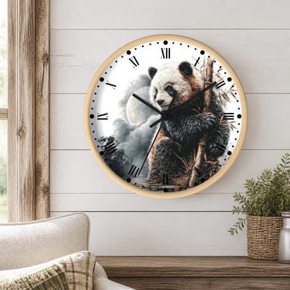 A round wall clock with a light wood frame hangs on a white shiplap wall above a wooden table. The clock face features a detailed illustration of a panda holding bamboo branches against a cloudy sky with a moon.