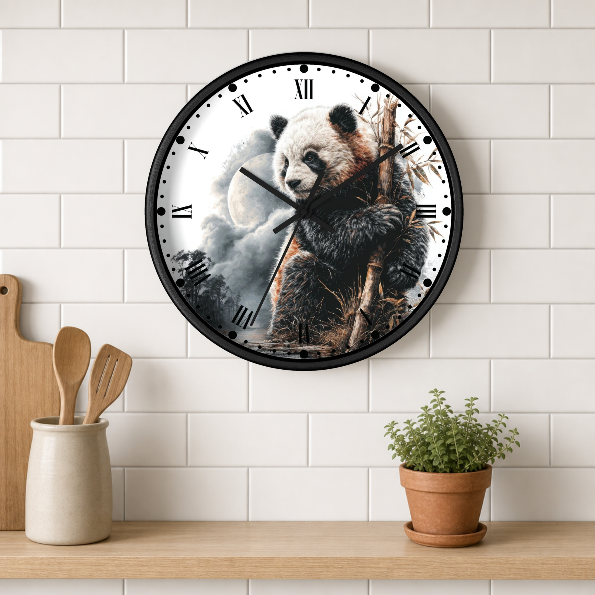 A round wall clock with a black frame and a panda illustration on the face, mounted on a white subway tile wall above a wooden shelf with a small potted plant and wooden utensils.