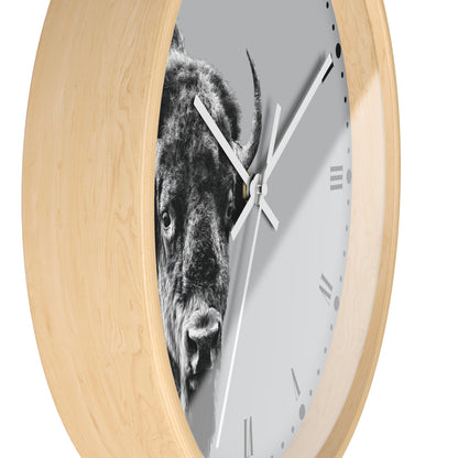 Round wall clock with a light natural wood frame and a white face featuring a black-and-white close-up photograph of a bison.