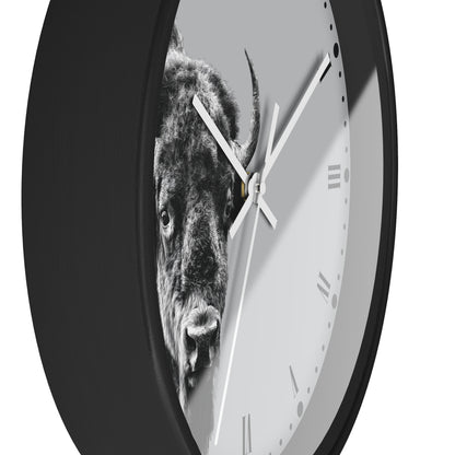 A round wall clock with a black frame and a light gray face featuring a black-and-white bison graphic. The clock is shown at an angle against a plain white background.