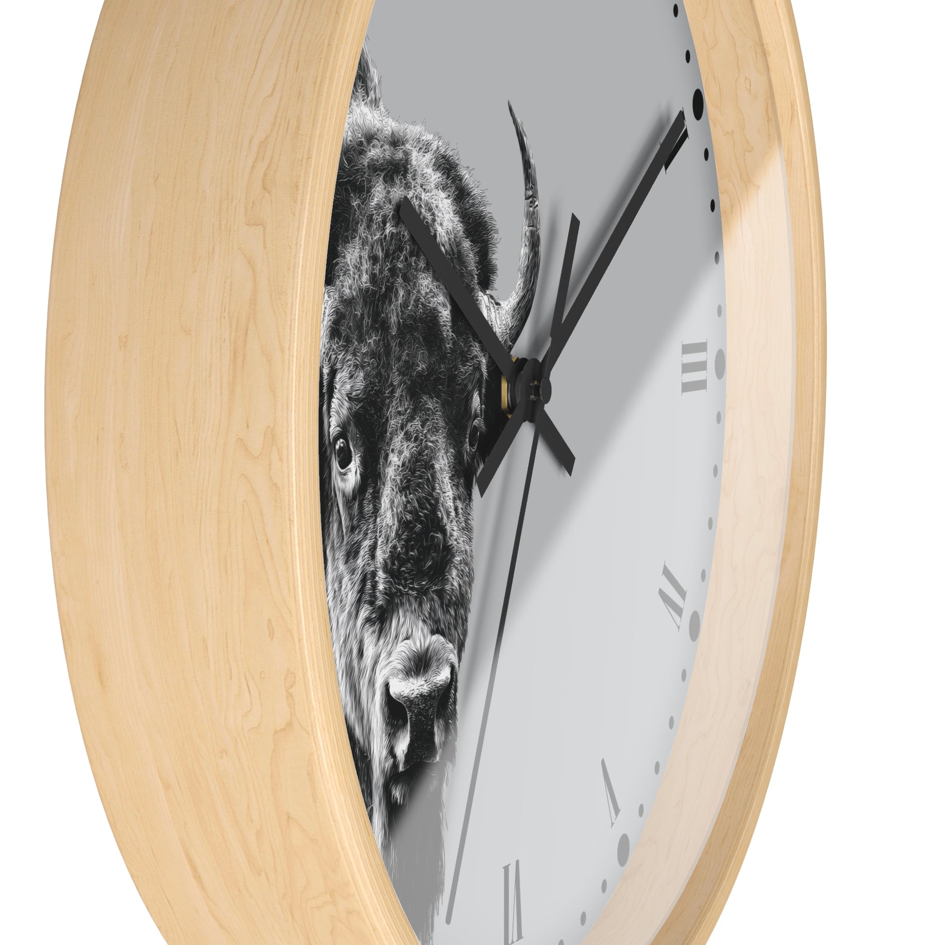A round wall clock with a light natural wood frame and a white dial featuring a black-and-white close-up photograph of a bison. The clock has black hands and minimalist Roman numerals.