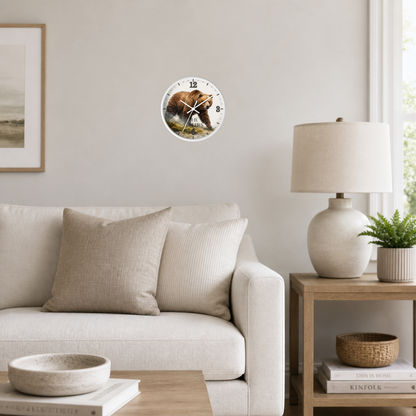 A round wall clock with a colorful floral and bird illustration, mounted on a light beige wall in a modern living room setting with a sofa, side table, and lamp.