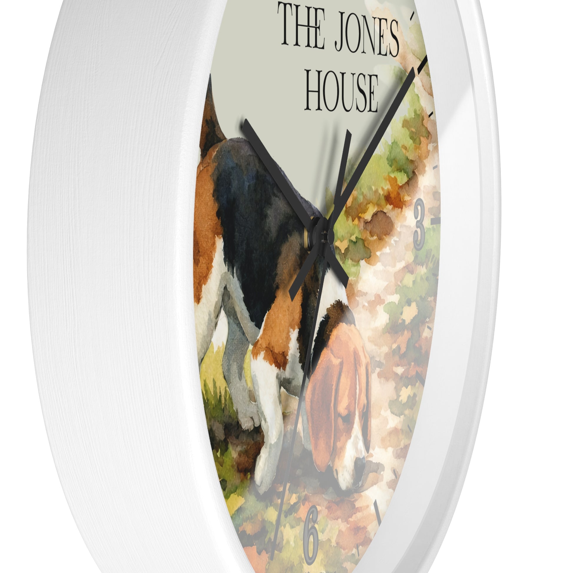 A round white wall clock featuring a watercolor-style illustration of a tricolor dog on the face, with the words 'THE JONES HOUSE' at the top and black hands.