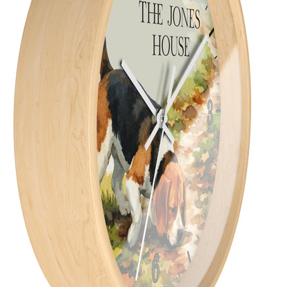 Round wall clock with a light natural wood frame and a printed dial showing a beagle dog on a path, with the text 'THE JONES HOUSE' at the top.