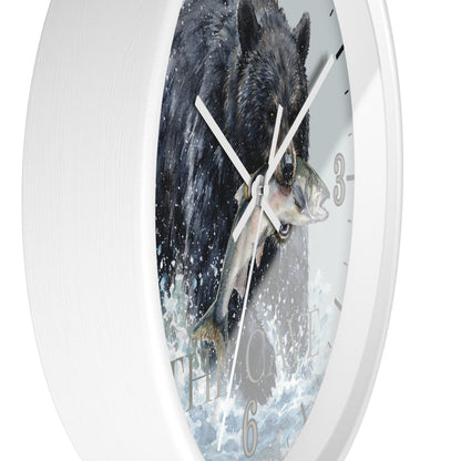 A white round wall clock featuring a printed design of a black bear catching a fish in splashing water, with white hands and gray Arabic numerals.