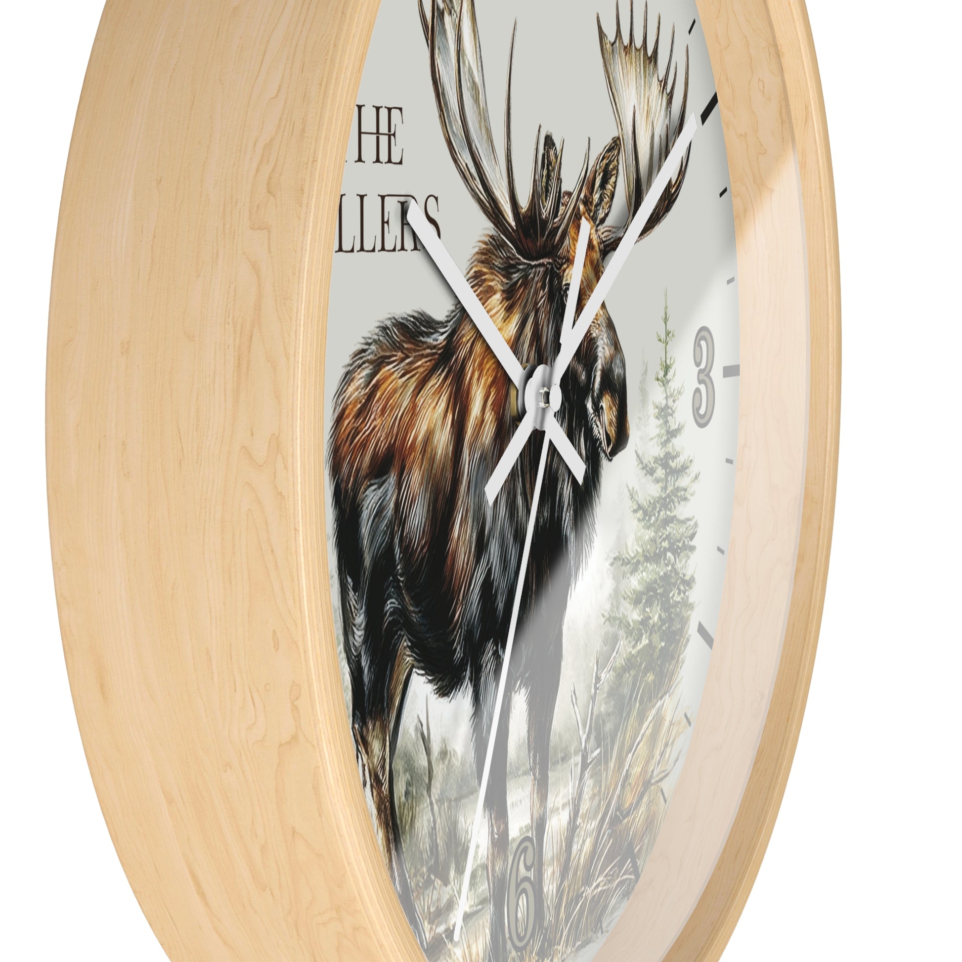 Round wall clock with a light natural wood frame and a printed face featuring a moose illustration, partial text, and black hour markers.