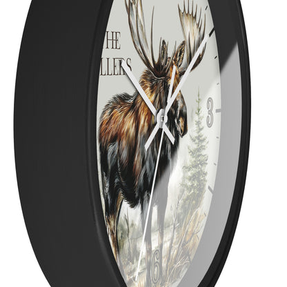 A round wall clock with a black frame and a white dial featuring a detailed illustration of a moose, trees, and the text 'THE MILLERS'.