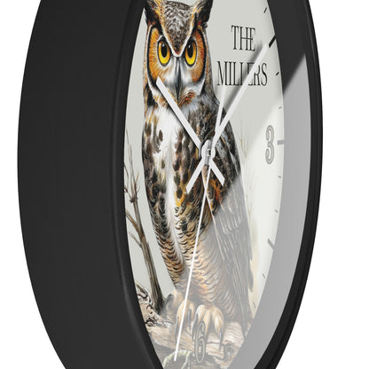 A round wall clock with a black frame and a white face featuring a detailed illustration of a great horned owl. The text 'THE MILLERS' is printed on the clock face, along with black Arabic numerals.