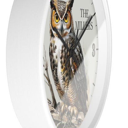 A round white wall clock featuring a detailed illustration of a great horned owl on the face, with black hands, black hour markers, and the text 'THE MILLERS' near the top right.